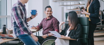 Four coworkers having a conversation in an office.